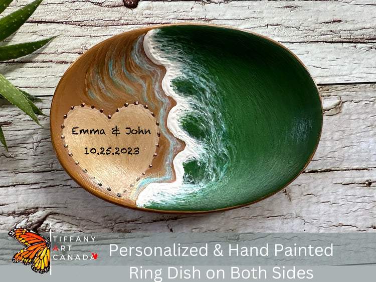 Photo with a hand-painted ring dish featuring a green water sea theme and a beach with a heart on it. You can personalize it with the couple's names and date.