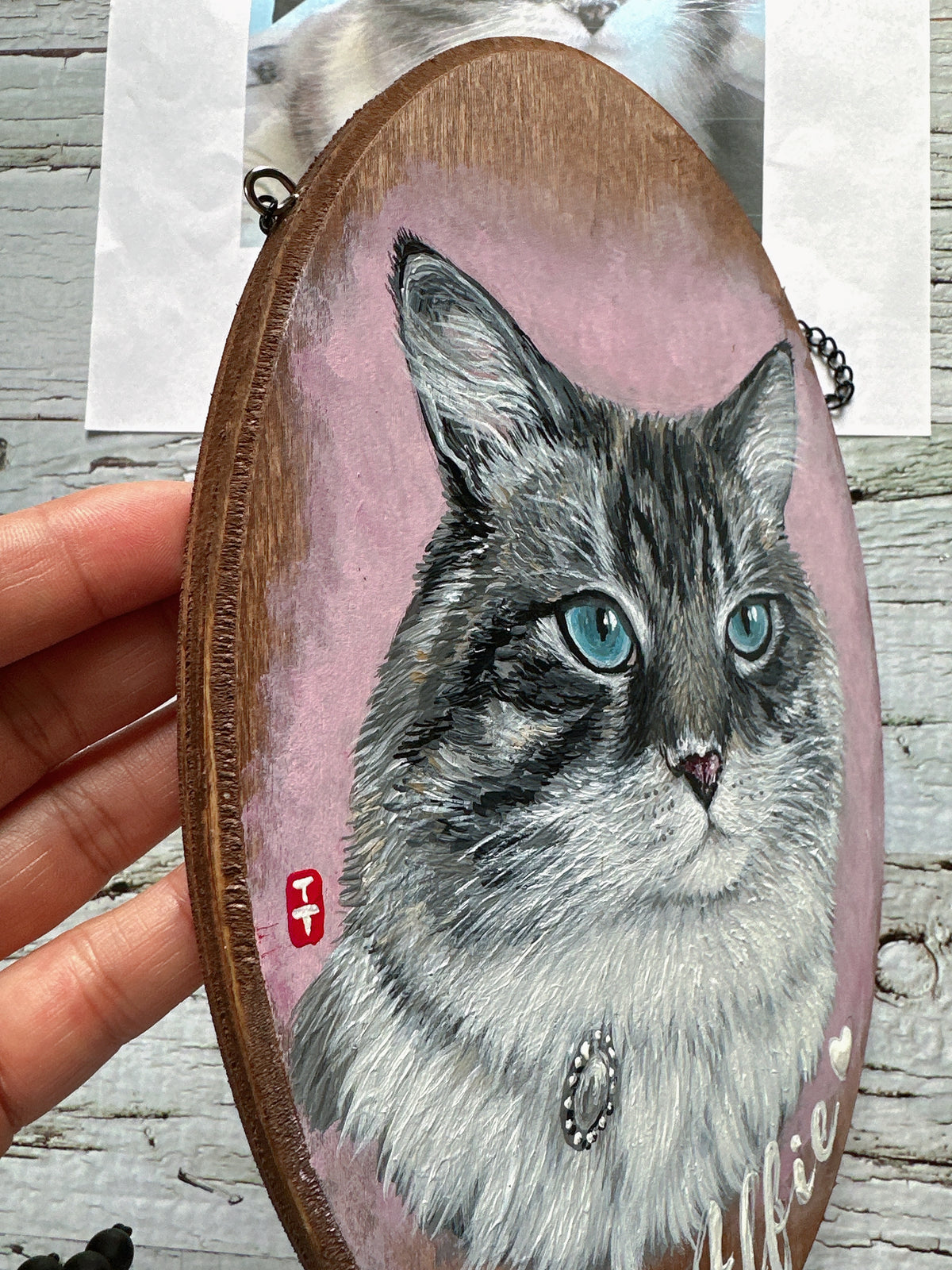 Side view of the hand-painted cat portrait plaque showing the wood edge and layered fur brush strokes